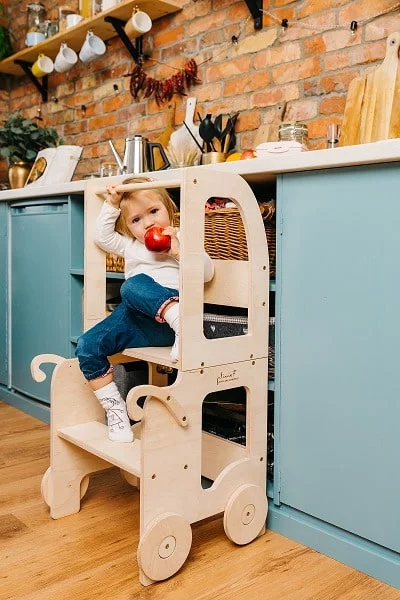 tour d'apprentissage a partir de quel age Tour Montessori en bois avec un enfant qui s'accroche à la barre de sécurité